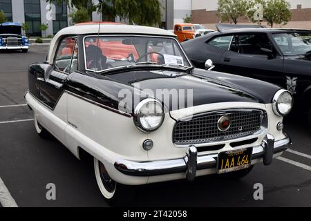 An antique automobile is parked in the parking lot of a vintage building, showcasing a classic style Stock Photo