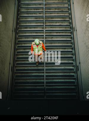 An overhead shot of a construction worker going downstairs. Stock Photo