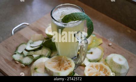 A glass of fresh lemonade with lemons and lime on a wooden board Stock Photo