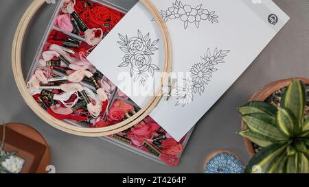 Hand embroidery flower patterns on a paper to stitch on a wooden stand hoop. Stock Photo