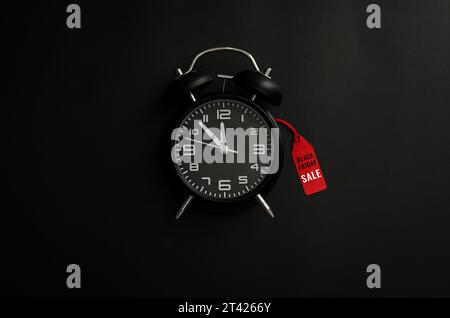 Alarm clock with word at red price tag on dark background for Black Friday shopping sale reminder concept. Stock Photo