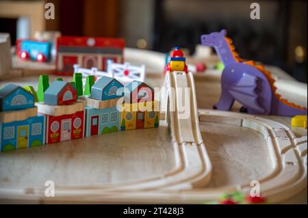 An eclectic collection of children's toys arranged in the shape of a train, on a wooden table Stock Photo