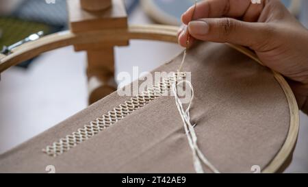 Artistry Unveiled: Women's Hand Stitching Border Pattern on Linen Fabric Stock Photo