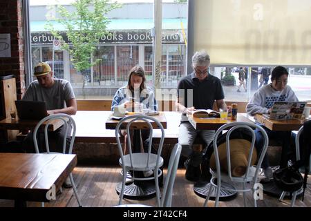 A group o sitting and working on their laptops at a cozy restaurant, enjoying each other's company Stock Photo