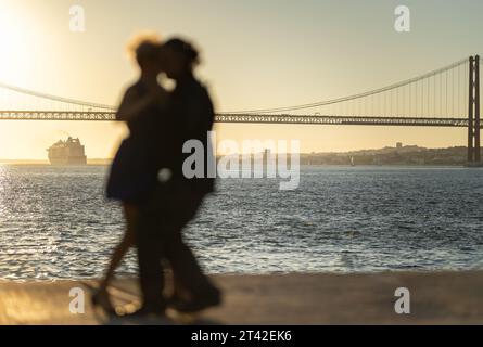 Couple silhouette embracing and dancing near waterfront - big cruise liner ship on background Stock Photo