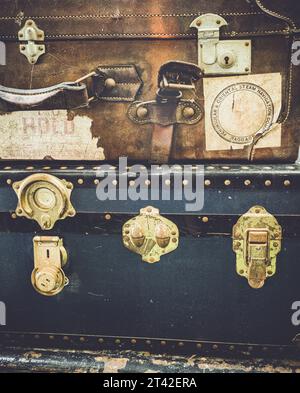 A vintage black and brown leather briefcase placed in the foreground of the image against a neutral background Stock Photo