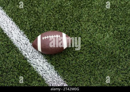 Football by a yard marker on a football field Stock Photo