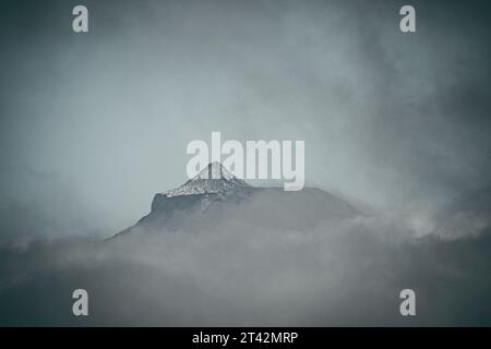 Aerial view of a mountain range surrounded by clouds Stock Photo