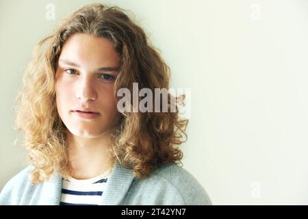 Long hair, man or fashion for portrait on mockup space in studio in hipster style clothing on white background. Face, person or headshot of stylish Stock Photo