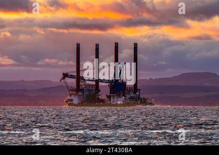 Jack-up vessel Sea Challenger heading out to sea at sunset Stock Photo
