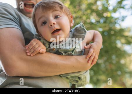 Close-up of a father standing in a garden holding his daughter, Belarus Stock Photo