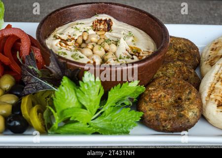 Close-up of a bowl of hummus with chickpeas, olive oil and spices Stock Photo