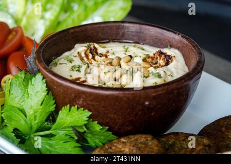 Close-up of a bowl of hummus with chickpeas, olive oil and spices Stock Photo