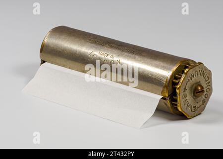 An Evans Patent Concinnum Machine, a vintage cigarette rolling device.  Closed view with a cigarette paper inserted in the side slot. Stock Photo