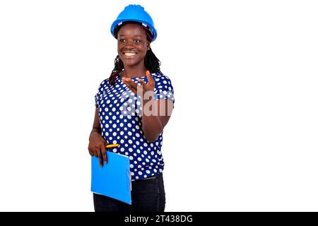 beautiful young female construction engineer holding a clipboard while smiling. Stock Photo
