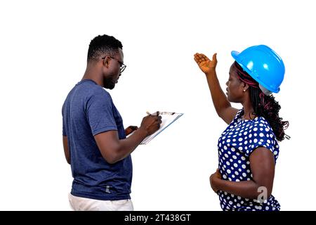 two young construction engineers working together. man writing notes to clipboard. Stock Photo