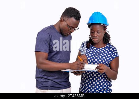 two young construction engineers working on a project together. man holding clipboard. Stock Photo