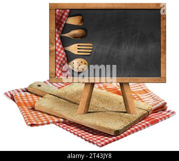 Old wood cutting board and empty blackboard with wooden kitchen utensils and copy space, on checkered tablecloths, red, orange and white. Stock Photo