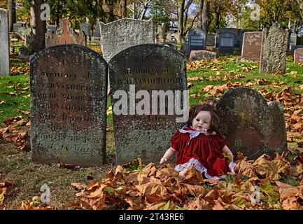 An old cemetery in an 1776 English Reform Church yard. With a one eyed doll. The color photo is a scary,look for Halloween. Stock Photo