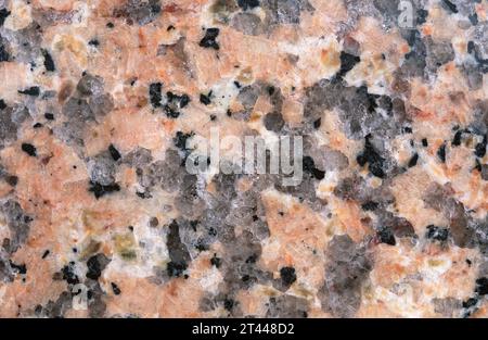 Pink granite. Granite is an igneous intrusive rock with holocrystalline texture. Polished surface. Stock Photo