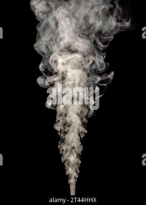 White smoke rises in a thick stream isolated on a black background Stock Photo