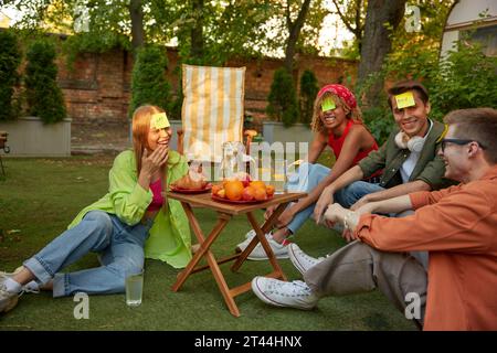 Group of friends playing funny game near trailer Stock Photo