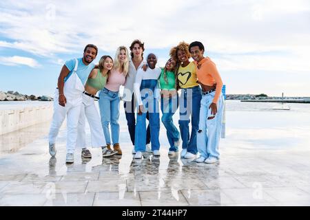 Group of multi-ethnic friends standing together next to the sea Stock Photo