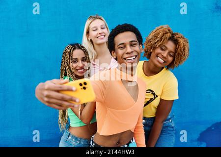 gay man and multi-ethnic female friends taking a selfie Stock Photo