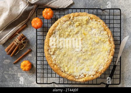 Fall traditional pie pumpkin with crumble and pecan on a gray stone background. Thanksgiving dessert. View from above. Stock Photo