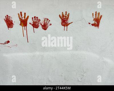 handprints, horror or Halloween background or surface with bloody red hands print on white wall with copy space. halloween background with hand shaped Stock Photo