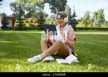 Elderly woman talking with relatives using videocall app on mobile tablet Stock Photo