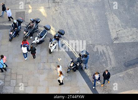 View from above, row delivery motor scooter bikes parked on pavement and and pedestrians passing, Oxford Stock Photo