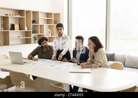 Serious young project manager woman explaining sales marketing colleagues Stock Photo