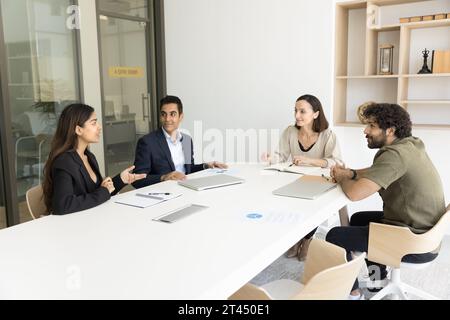 Business colleagues of different ages talking at meeting table Stock Photo
