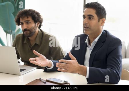 Serious Indian businessman in formal jacket talking partners Stock Photo