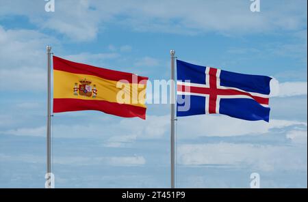 Iceland and Spain flags waving together in the wind on blue cloudy sky, two country relationship concept Stock Photo