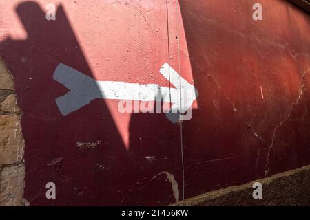 white arrow on red wall painted sign Stock Photo