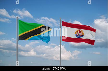 Tanzania and French Polynesia flags waving together in the wind on blue ...