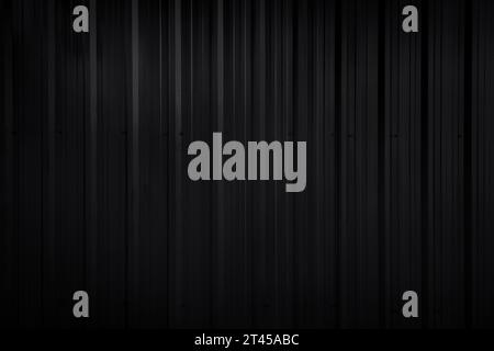 Front view of dark gray, almost black, corrugated galvanized metal wall. Abstract high resolution full frame textured background, copy space. Stock Photo