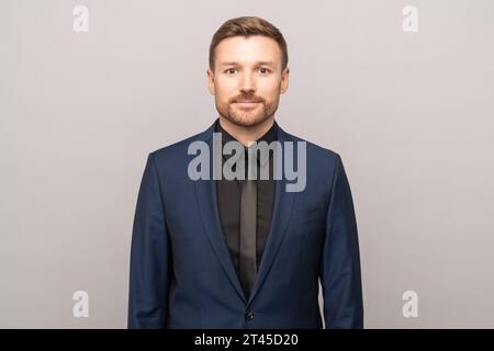 Successful serious confident handsome middle-aged man isolated on grey background looking at camera Stock Photo