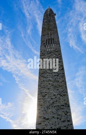 93 meter stone obelisk commemorating American Revolutionary War Battle of Bennington stands in brightly lit cloud swept blue sky Stock Photo