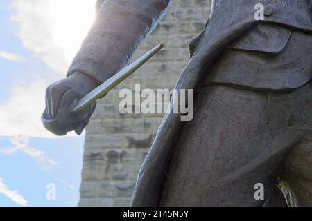 Close up saber wielded by 1889 bronze stature of General John Stark by sculptor John Rogers brightly back lit  by cloud swept blue sky — October 2023 Stock Photo