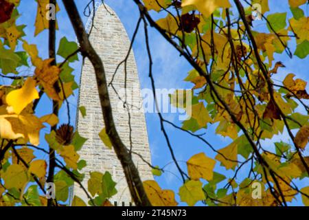 93 meter limestone obelisk commemorating American Revolutionary War Battle of Bennington stands behind bright autumn colored tree Stock Photo