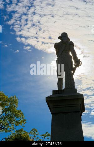 Silhouette 1911 granite statue of Colonel Seth Warner brightly back lit with cloud swept blue sky — Bennington, Vermont, October 202 Stock Photo