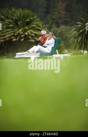 Grass, garden and old couple on holiday with laptop, villa and relax on online post, email or connection. Hotel in countryside, senior man and woman Stock Photo