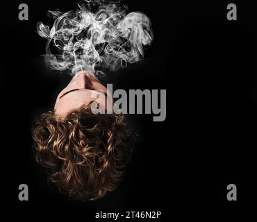 Man smoking marijuana, drugs or cigarette in studio isolated on black background mockup. Smoke, vape and person exhale cannabis, weed and addiction to Stock Photo