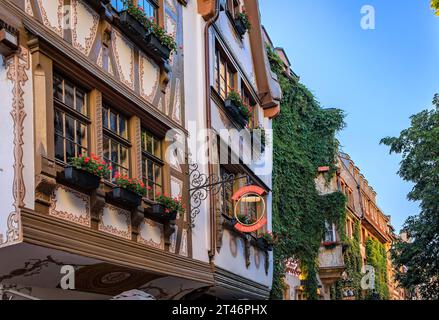 Strasbourg, France - May 31, 2023: Ornate facades of Alsatian winstub restaurants in traditional half timbered houses in the historic center at sunset Stock Photo