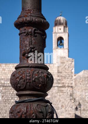 DUBROVNIK, CROATIA - SEPTEMBER 12, 2023:  Old rusty ornate lamp post with the Bell Tower in the background Stock Photo