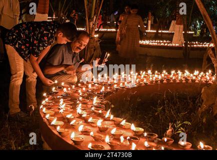 Mumbai, India. 28th Oct, 2023. Father and son are seen lighting earthen lamps on the occasion of Sharad Purnima (full moon) in Mumbai. Sharad Purnima or the full moon marks the end of monsoon season and is celebrated across South Asia by the Hindus in many different ways in the month of September-October. devotees observe fast on the full moon night. goddess of wealth, Lakshmi is worshipped on this day as it is believed to be her birthday, and praying to her brings good luck and wealth. (Photo by Ashish Vaishnav/SOPA Images/Sipa USA) Credit: Sipa USA/Alamy Live News Stock Photo