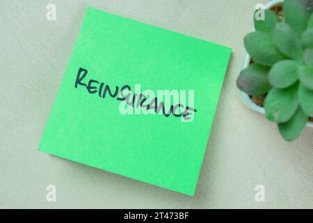 Concept of Reinsurance write on sticky notes isolated on Wooden Table. Stock Photo